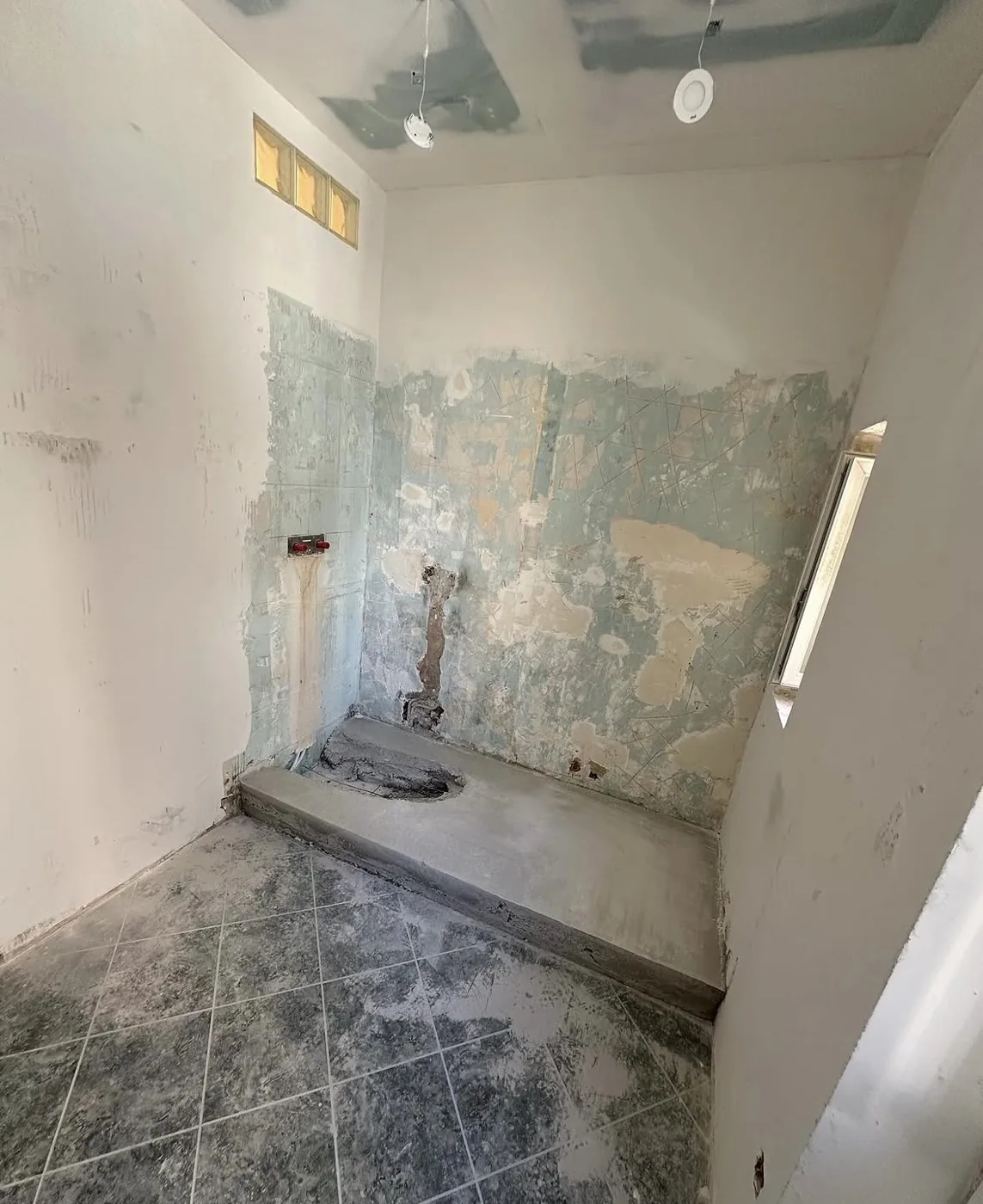 Espace douche en préparation, supports et évacuation apparents