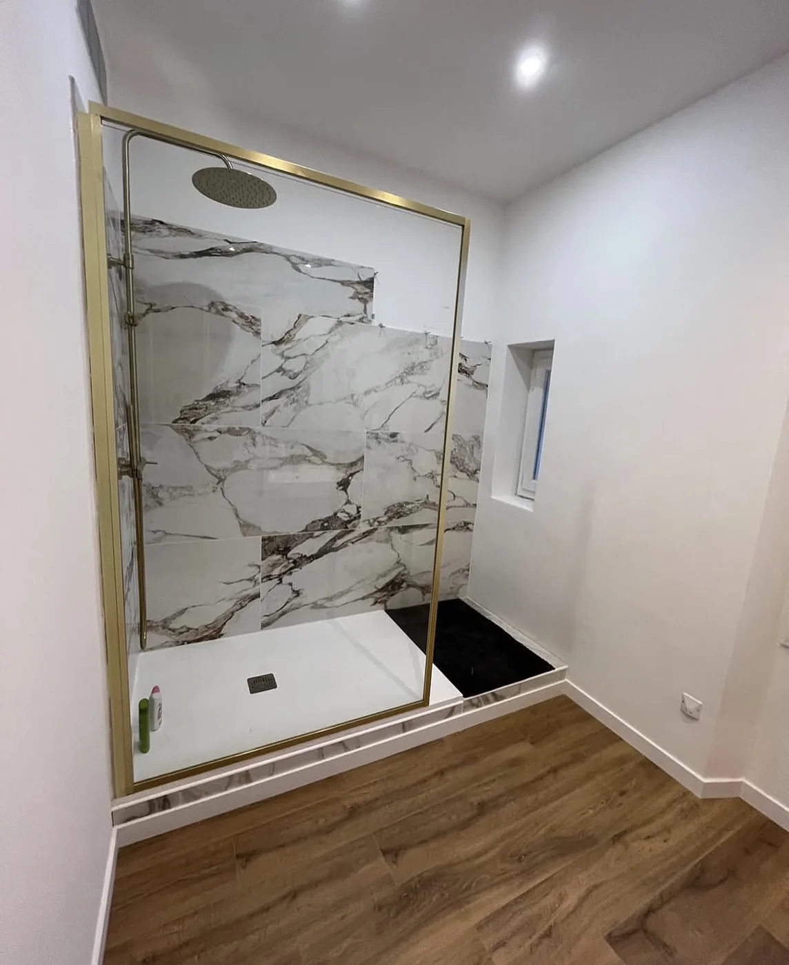 Douche terminée, faïence effet marbre et paroi dorée